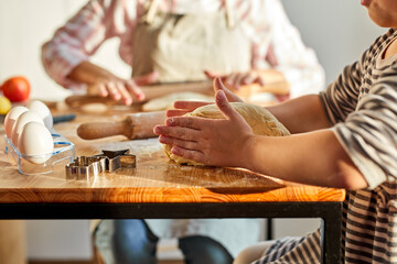 mother and daughter kneading dough for homemade dessert in kitchen, teach and learn