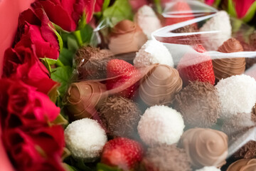 Fototapeta na wymiar fresh strawberries covered with chocolate and coconut. Gift set with strawberries and red roses