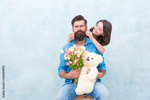 happy family portrait with teddy bear. spring flower bouquet. womens day. prepare tulips for mothers day. daughter and father celebrate birthday. girl greeting dad with fathers day. family love