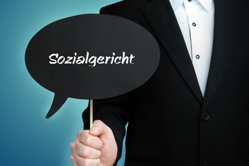 Sozialgericht. Mann (Anwalt) hält Schild mit Beschriftung. Sprechblase mit Text (deutsch). Hintergrund blau