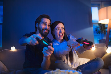 Young couple in love playing computer games indoors at home.