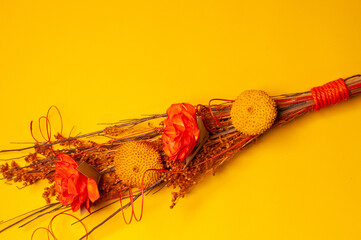 bouquet of pink flowers on the left side on a yellow background and a pink leaf