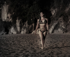 chica morena caminando por la playa