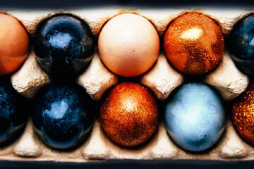 Naturally dyed black, blue, gray, beige, golden Easter eggs pattern.