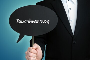 Tauschvertrag. Mann (Anwalt) hält Schild mit Beschriftung. Sprechblase mit Text (deutsch). Hintergrund blau