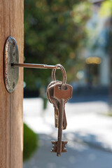 Set of keys on the ring in the keyhole with blurred street background, selective focus