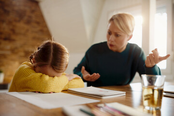 Small girl being scolded by her mother during homeschooling.
