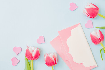 Flat lay valentines day frame with pink tulips on a light green background