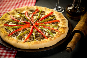 Pizza - tradicional brasileira, vegetais, ingredientes em um fundo escuro de madeira envelhecida. Espaço para texto.