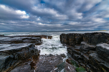 Fototapeta na wymiar The Atlantic ocean waves crashing in to the cliffs off the west coast of Ireland, County Donegal, Creavy pier