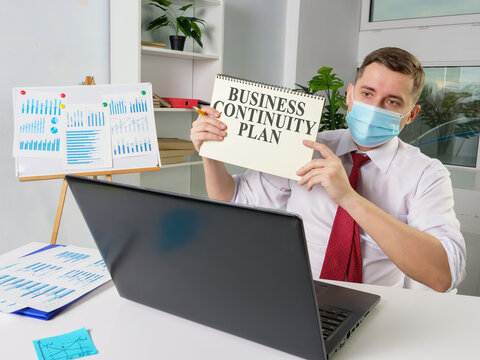 Man In Face Mask Shows Business Continuity Plan While Online Meeting.