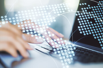 Abstract creative world map with connections and hands typing on laptop on background,...