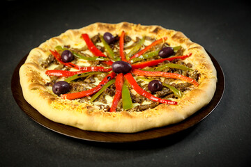 Pizza - tradicional brasileira, vegetais, ingredientes em um fundo escuro de madeira envelhecida. Espaço para texto.