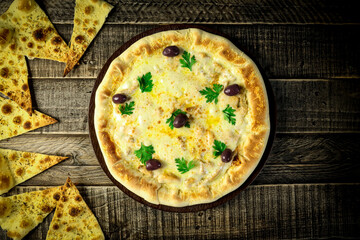 Pizza - tradicional brasileira, vegetais, ingredientes em um fundo escuro de madeira envelhecida. Espaço para texto.