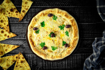 Pizza - tradicional brasileira, vegetais, ingredientes em um fundo escuro de madeira envelhecida. Espaço para texto.