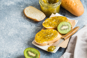 jam or marmalade made from kiwi on fresh bread. breakfast, toast with jam on a gray background