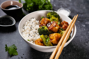 Asian vegan bowl with rice, broccoli and fried tofu