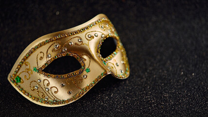 Festive, colorful Mardi Gras or carnivale mask on glitter black background. Venetian masks. Party invitation, greeting card, venetian carnivale celebration concept.