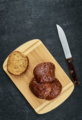 Rye buns with flax, pumpkin and sunflower seeds on a wooden board, top view