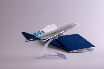 Booking flight concept backdrop with airplane model, passports, money, and boarding pass documents on the grey background