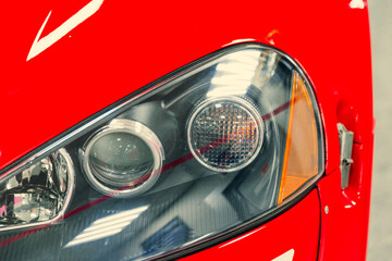 close-up of the front halogen headlights of a red car