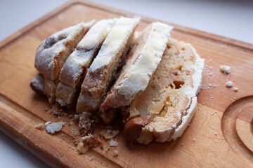 On a cutting board, pieces of chopped stollen, traditional German Christmas pastries.
