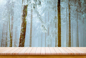 Wooden board with snowy forest background. Empty wooden table with copy space