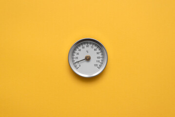 Water temperature meter on the yellow abstract background.