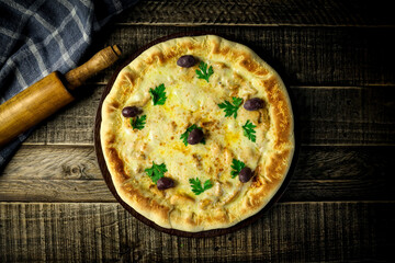 Pizza - tradicional brasileira, vegetais, ingredientes em um fundo escuro de madeira envelhecida. Espaço para texto.