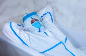 Doctor wearing medical protective suit, mask, and gloves lying in the bath. Relax after work. Protection mers by virus epidemic. Coronavirus (COVID-19). Healthcare concept.