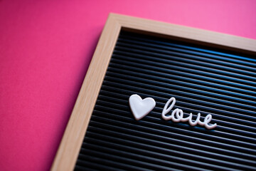 Message for Valentine's day with the word "love" on a board with pink background