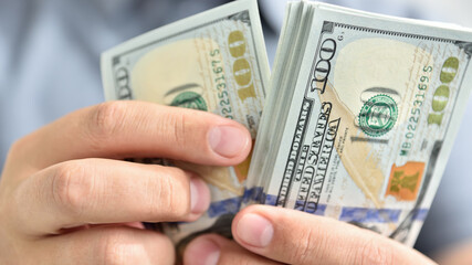 Businessman hands counting cash dollars.