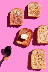 Toasts with butter and strawberry jam on a pink background. Funny colorful food concept. Minimalist...