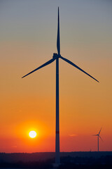 Fototapeta na wymiar Wind turbines at sunset in the country side. Golden hour