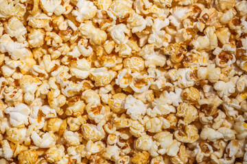 Heap of delicious popcorn, isolated on white background. Scattered popcorn texture background. Top view.popcorn with caramel