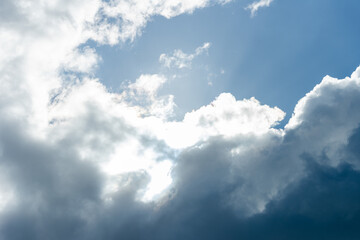 Fototapeta premium rays of the sun shine through the clouds in the blue sky