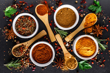 Various spices a vintage spoons on stone table. Colorful Herbal and Spices Oriental marketplace.Top view . Cafe concept. Delicious food delivery.