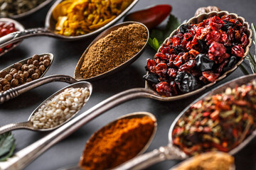 Various spices a vintage spoons on stone table. Colorful Herbal and Spices Oriental marketplace.Top view . Cafe concept. Delicious food delivery.