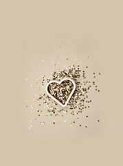 Gold  star sparkles form of heart on grey pastel trendy background. Festive background for valentines day