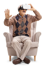 Elderly gentleman sitting in an armchair and using a VR headset