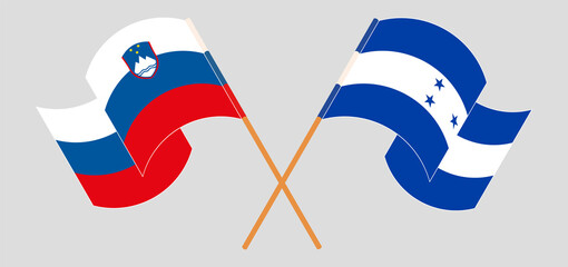 Crossed and waving flags of Slovenia and Honduras