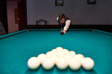 man holding arm on billiard table, playing snooker game or preparing aiming to shoot pool balls....