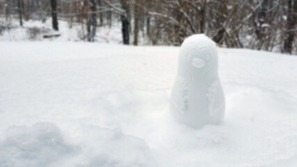 Snow penguin in winter Landscape, building a different snowman