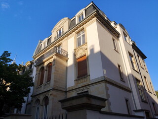 Schöne alte Villa in Beige, Ocker und Naturfarben im Licht der untergehenden Sonne vor blauem...