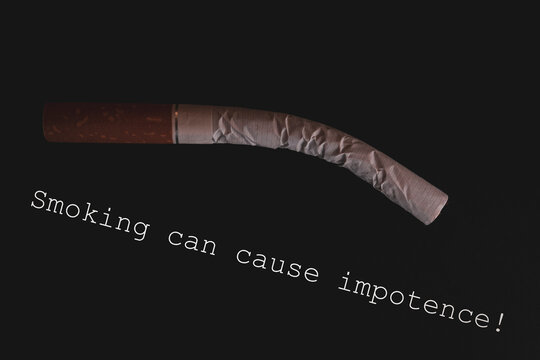 Folded cigarette on a black background. Warning that smoking can cause impotence