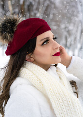 Attractive bright portrait of young brunette Caucasian lady with long wavy hair and red lips in winter time