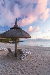 Sunrise at the beach. Dried grass umbrellas shadows. Calm, zen, holiday, summer vibes, relaxation mood on