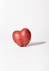 Ugly heart shaped potatoes on white background with text space.