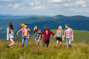 Friends on mountain walking. Weekend at nature. People enjoying picnic on sunny day. Summer vacations.