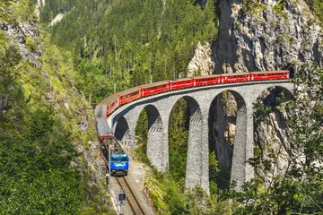 Photo sur Plexiglas Viaduc de Landwasser Viaduc de Landwasser à Filisur, Suisse. C& 39 est le célèbre point de repère de la Suisse. Train express rouge sur un pont élevé dans les montagnes. Vue panoramique sur le chemin de fer incroyable en été. Concept de voyage en Europe alpine.